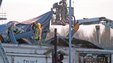 Firefighters at the Clutha bar in Stockwell Street, Glasgow, after police helicopter crashed into the roof of the building